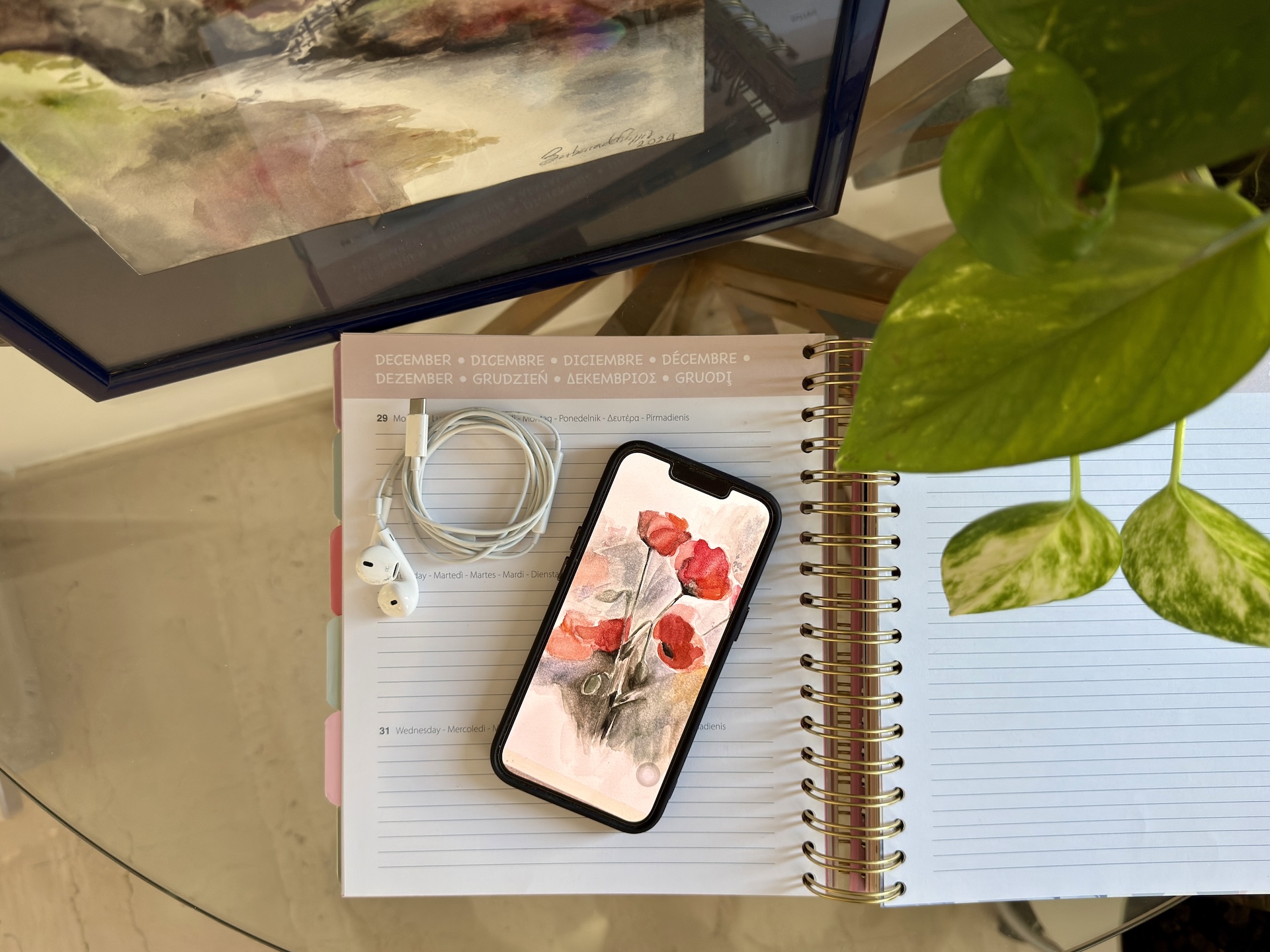 Smartphone con sfondo che riproduce un quadro ad acquerello, agenda e cuffie per cellulare