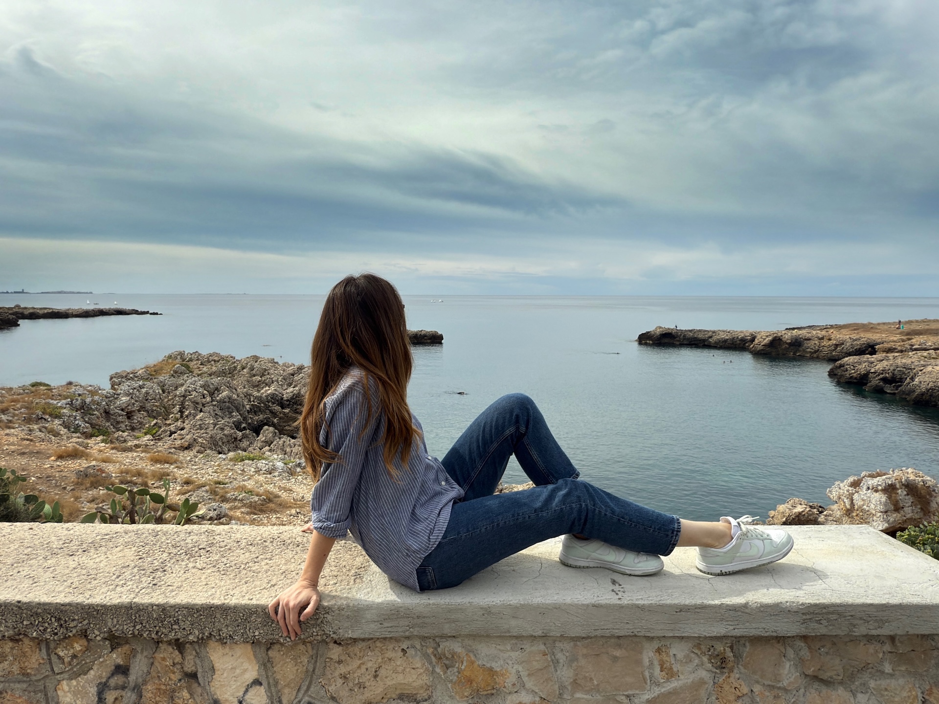 Ragazza che contempla il mare salentino e ne trae ispirazione