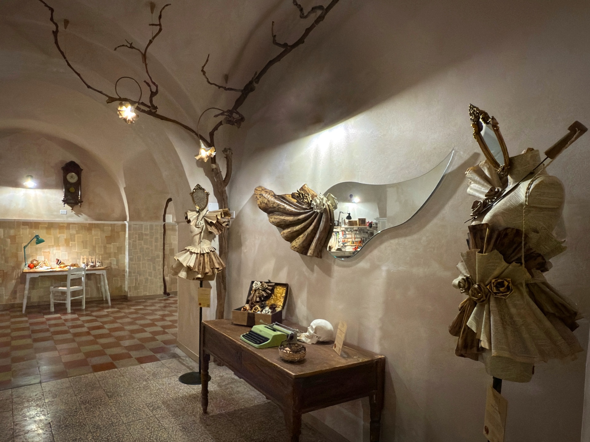 Ingresso laboratorio di cartapesta con opere concettuali e specchio